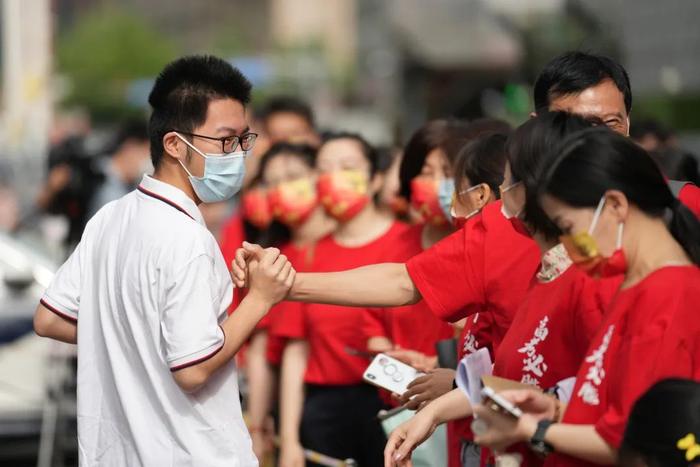 6月7日，北京，陈经纶中学考点，送考老师为即将进入考点的考生加油鼓劲。新华社 图