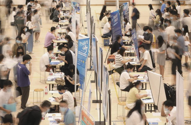 5月29日，江苏南京，大学生在招聘展台前咨询 图源：IC photo 