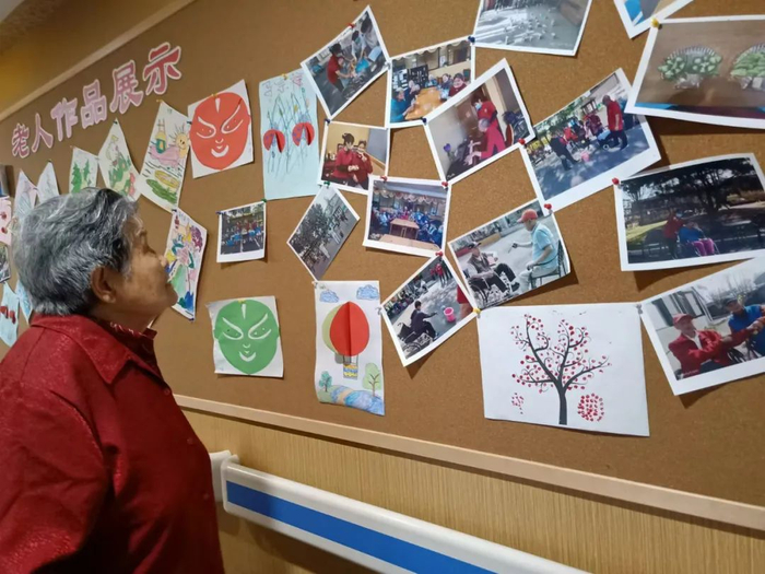 ▲在北京东坝福寿苑养老照料中心，老人们欣赏活动照片与手工作品。受访者供图