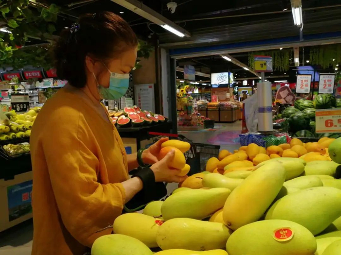 ▲消费者正在选购芒果。李建/摄