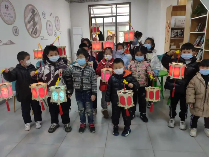 小朋友们展示自己做的灯彩手工作品。