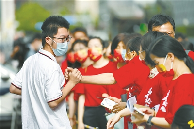 　　6月7日，2022年全国高考拉开帷幕。图为在北京市陈经纶中学考点外，送考老师为即将进入考点的考生（左）加油鼓劲。 新华社记者 鞠焕宗 摄