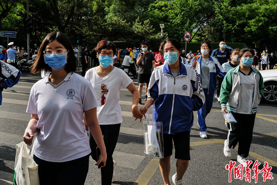     6月7日，北京一零一中学考点外，一名考生牵着家长的手，准备进入考场。中青报·中青网记者 赵迪/摄