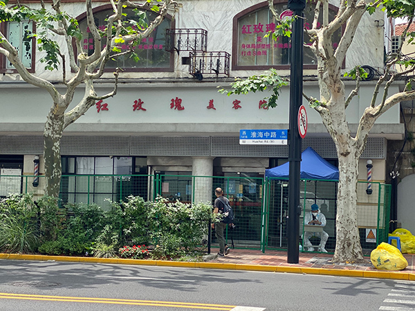 6月9日下午，红玫瑰美容院已经被绿色铁栅栏围住，门口有身穿大白防护服的人值守。 本文图均为 澎湃新闻记者俞凯 图（除署名外）