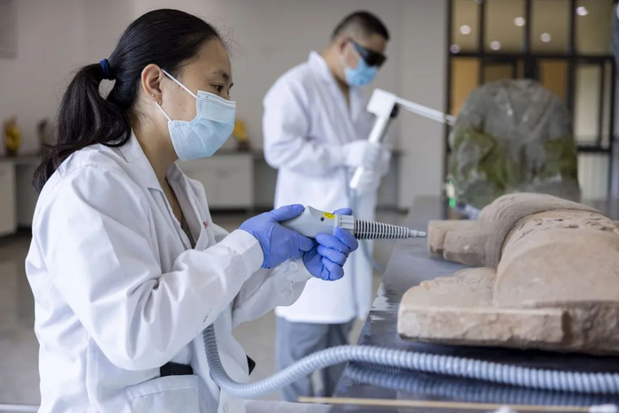 大足石刻文物医院，工作人员在进行文物修复。