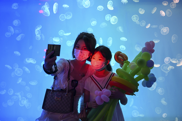 2022年6月12日，上海海昌海洋公园，游客在珊瑚水母馆自拍。