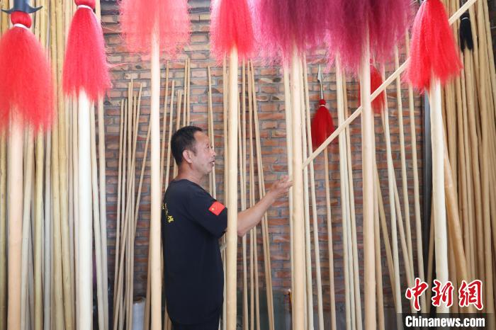 图为廊坊市安次区调河头镇南马庄村一蜡杆加工厂，工人正在展示蜡杆产品———武术棍、红缨枪。　贾珺 摄