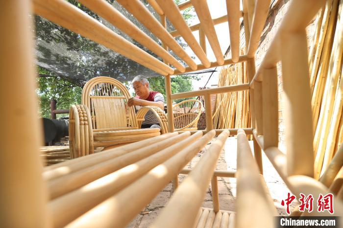 图为廊坊市安次区调河头镇南马庄村一蜡杆加工厂，工人正在制作蜡杆逍遥椅。　贾珺 摄