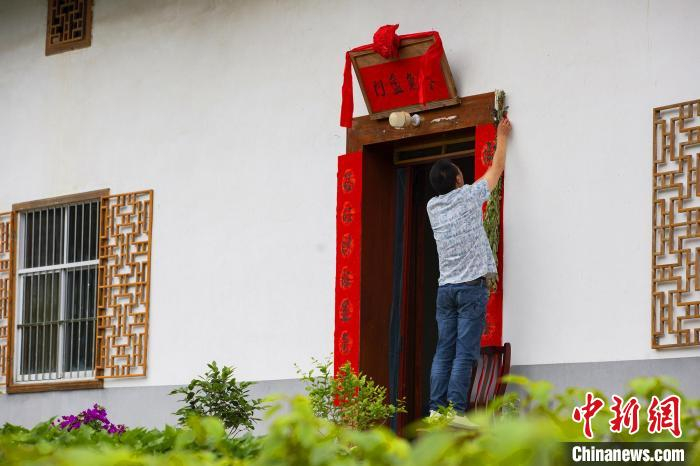 当地村民在门前贴端午对联、挂艾蒿。　聂爽 摄