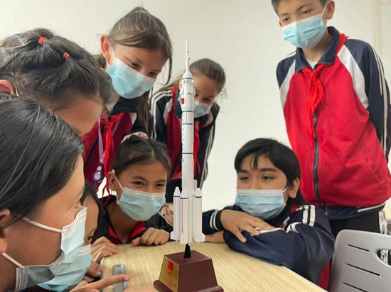     在新疆巴楚县第二小学开展的天文主题科普教育活动上，学生们观摩科技志愿服务队带来的航天模型。受访者供图