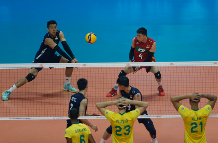 中国男排球员张景胤（上左）和杨一鸣（上右）在比赛中接球。&nbsp; 图/新华社