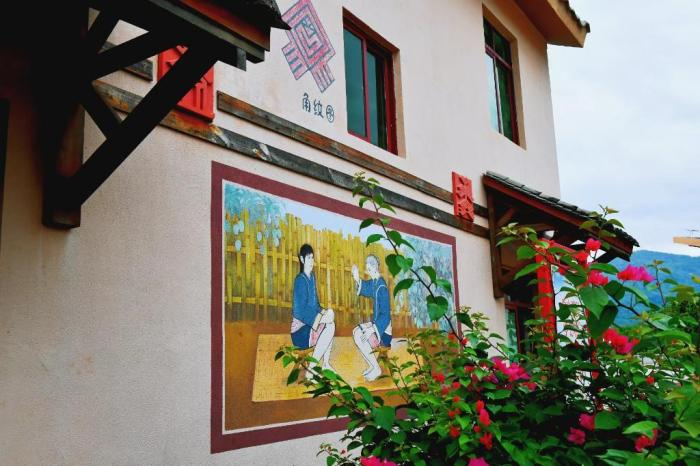 图为白沙高石老村内民居墙壁上富有民族风情的壁画。本报记者 符宇群 摄