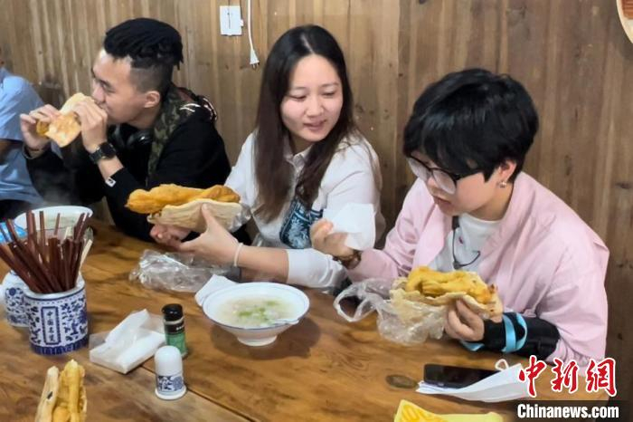 台湾青年品尝美食——大饼卷油条。　董易鑫 摄