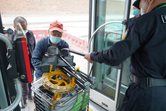 4月初，463路上的乘务员主动为乘客拎重物。中青报·中青网记者 魏晞/摄