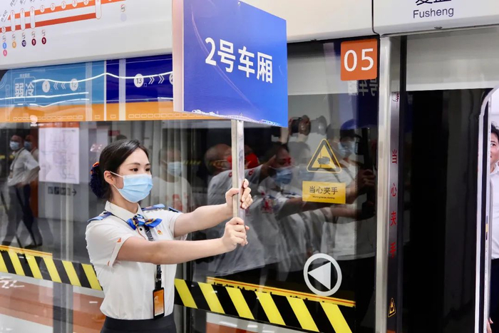 工作人员举牌指引 龚浩月 摄