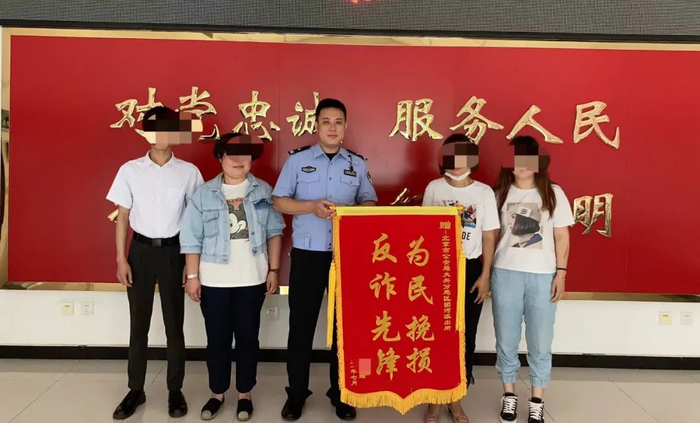 ▲大兴分局团河派出所副所长郭贺（中）在及时劝阻成功帮群众保住存款后收到了锦旗。受访者供图