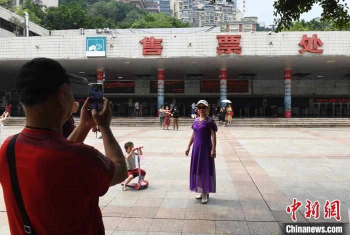 图为市民在重庆站售票大厅前的广场上拍照留念，与车站告别。　周毅 摄