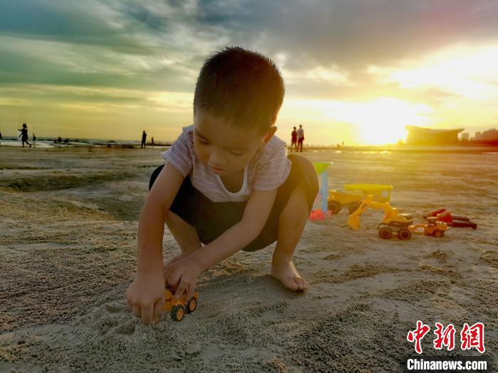 图为小男童在海滩上玩耍。　翟李强 摄