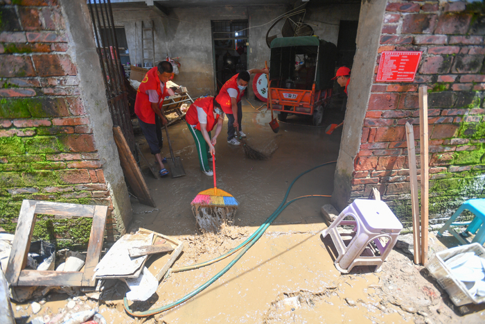 　　6月24日，在湖南省永州市道县万家庄街道，党员志愿者帮助居民清理淤泥。新华社记者　陈泽国　摄