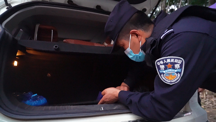 韩斌在车辆后备厢夹层中寻找毒品。受访者供图