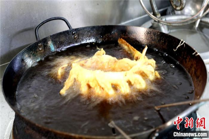 鲤鱼在油锅中定型。李欣 摄