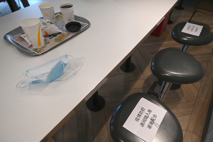 2022年6月29日，上海南方商城，一家餐饮店内，座位上贴有“请间隔入座”的标识。吴栋 图