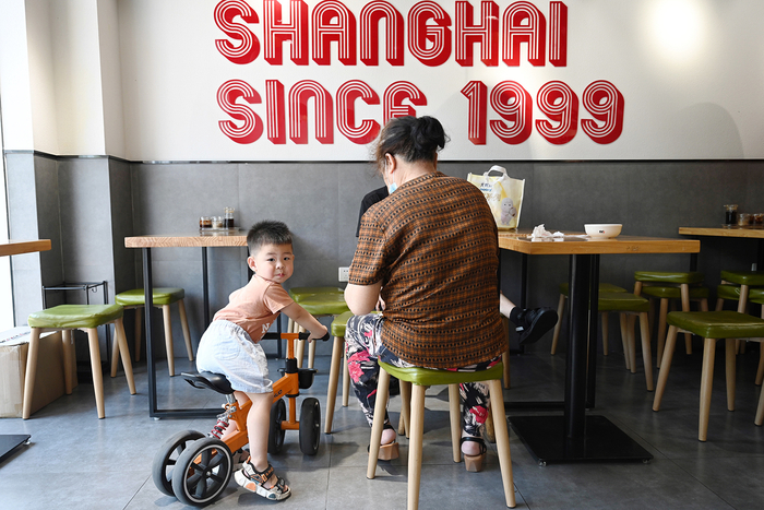 2022年6月29日，上海兴南路，一家餐饮店内，家长带小孩在店内就餐。朱伟辉 图