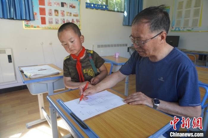 张吉堂批改布置的作业，且耐心开导金宇，以缓解他长期离群产生的孤独感。　九美旦增　摄
