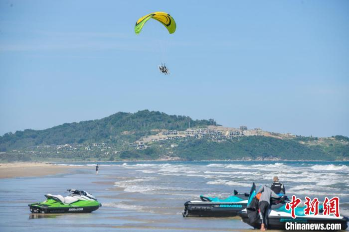 资料图：游客在万宁石梅湾体验动力滑翔伞。　骆云飞 摄