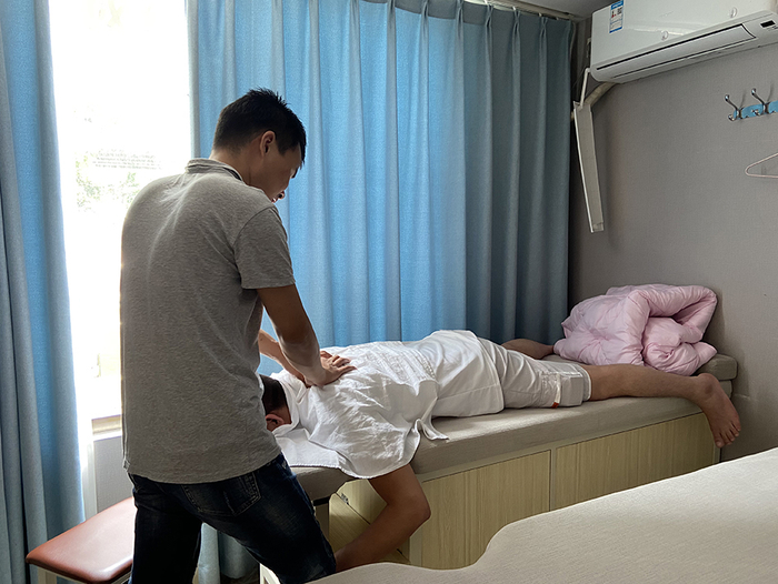 店员肩颈有些不舒服，晏丽华帮他推拿。