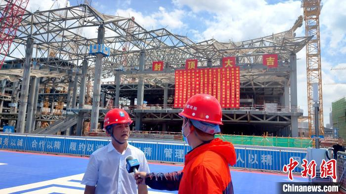 中建四局厦门东部体育会展新城项目相关负责人在封顶现场接受媒体采访。　杨伏山 摄