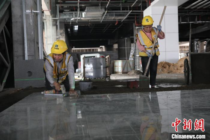 工人在铺贴瓷砖。　封荣权 摄