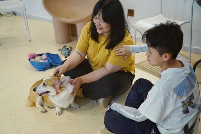 ▲4月17日，天通苑一家犬行为训练中心，大佟（右）指导学员田原（左）用泰灵顿触疗法安抚她的宠物犬“拿铁”。