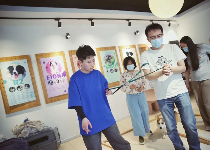 ▲4月10日，天通苑一家犬行为训练中心，牵引技巧团体课上，大佟让学员闭着眼睛，体验只靠牵引绳的“指令”走路。