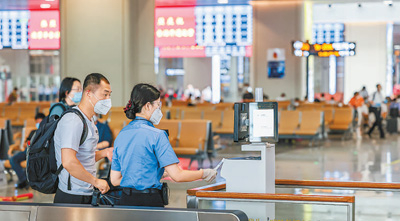 北京丰台站的工作人员引导旅客进站。本报记者 张武军摄