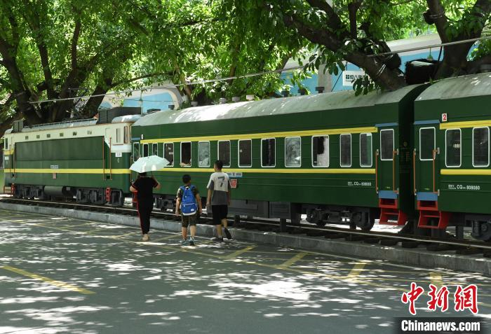 市民从“超级80街”内的绿皮火车旁经过。　周毅 摄