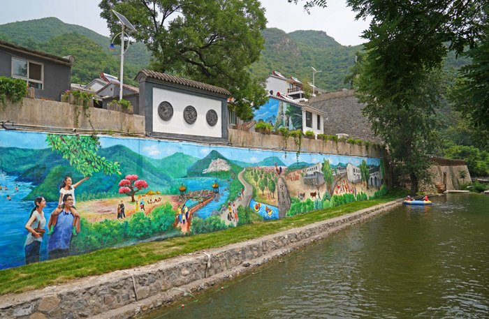 ▲樱桃采摘、景区漂流、精品民宿……村口的巨幅立体画将山村特色和美好生活展现给山外来客。