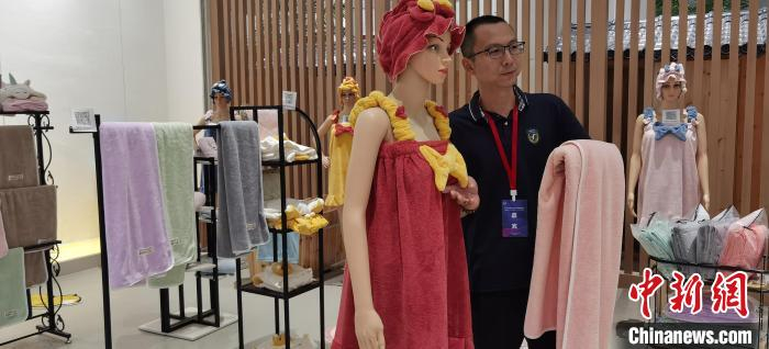 图为商家展示毛巾产品。　徐巧明 摄