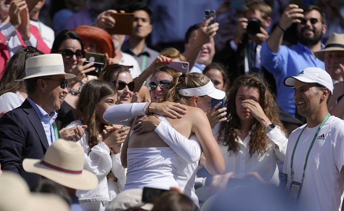 莱巴金娜获胜后与家人和团队拥抱。