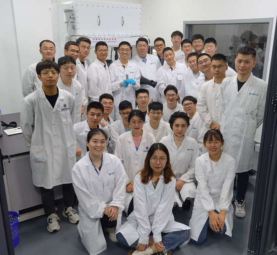     年轻的科研团队合影，后排居中戴蓝色手套者，手中捧着月壤样品。中科院宁波材料所供图