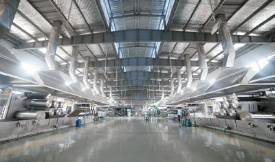 图为浙江省宁波大发化纤有限公司用来制作再生涤纶短纤维的牵伸工艺生产车间。 资料图片