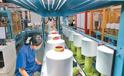 　2021年11月3日，工作人员在位于江苏省南通市通州区的恒力（南通）纺织新材料产业园二期项目生产车间进行质检。 许丛军摄（人民视觉）