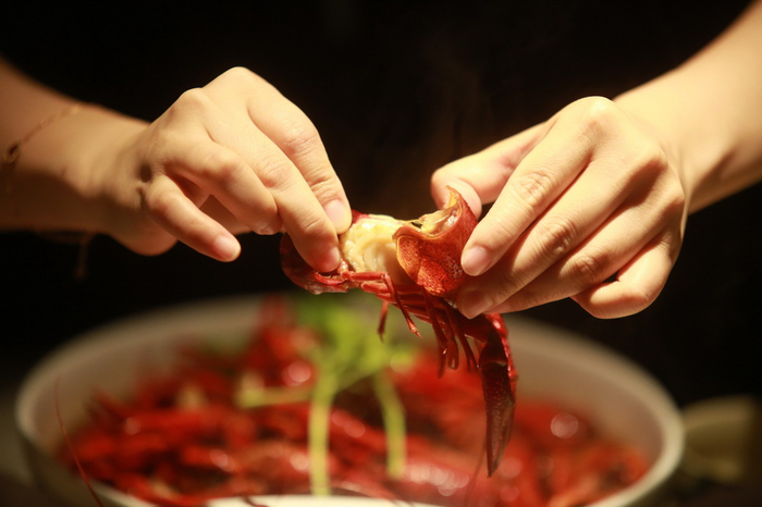 2022年7月9日，江苏扬州江都区邵伯镇夏季龙虾市集，游客品尝龙虾。