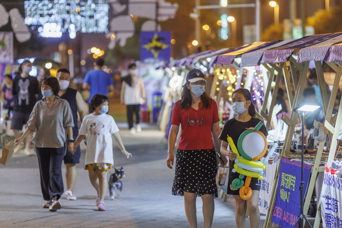 2022年6月30日，天津，大悦城南马路外广场，市民带着孩子畅游夜市。