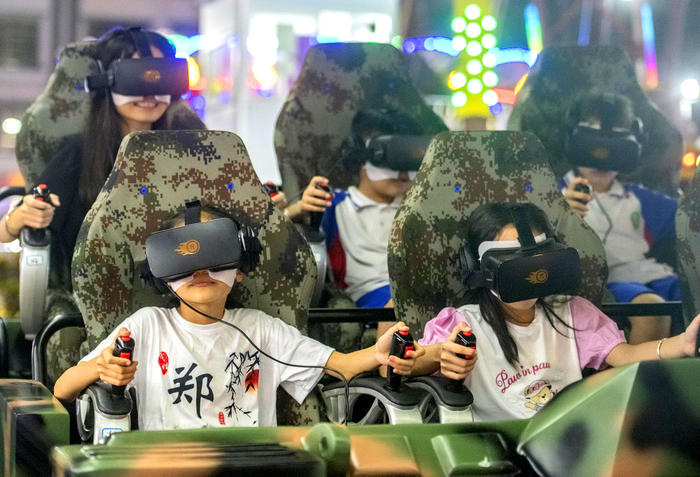 2022年7月8日，海南琼海万泉河广场游乐场，孩子们在VR设备上玩得不亦乐乎。