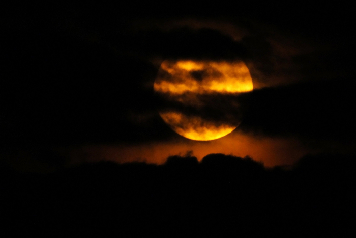 2022年7月13日，湖北宜昌，圆圆的月亮从乌云里露脸。