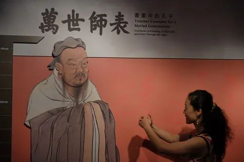 2017年7月13日，在台北故宫推出的孔子特展中，一位观众在孔子画像前模仿孔子作揖动作。新华社记者周密摄