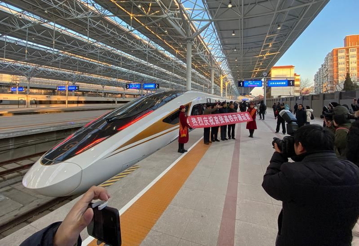 ▲2019年12月30日，G8811高铁列车乘务人员打出“热烈庆祝京张高铁开通运营”的条幅，乘客与京张高铁列车合影。新京报记者 王贵彬 摄&nbsp;
