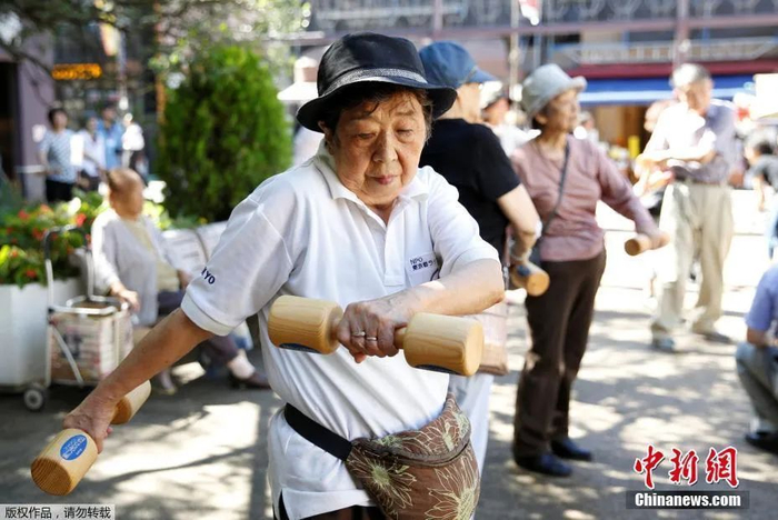 资料图：日本东京，老人们举木质哑铃锻炼身体。