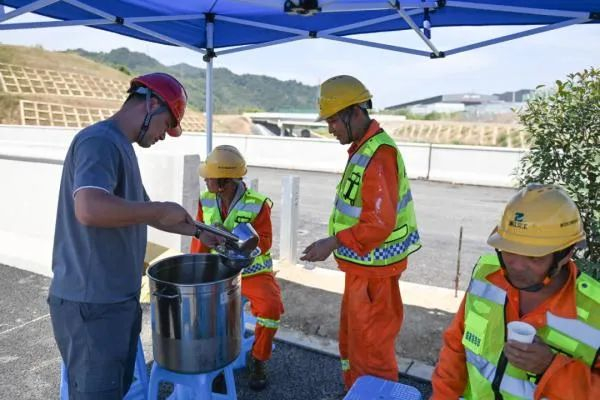 7月14日，在临建高速土建一标项目现场，工作人员为施工人员盛银耳汤消暑。新华社记者 黄宗治 摄